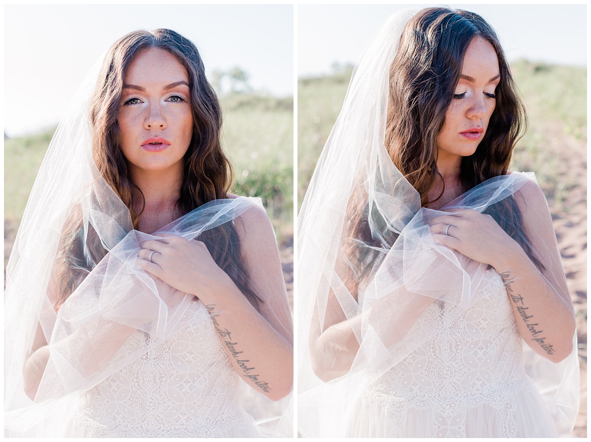 bride standing on a grassy beach with her cathedral veil wrapped delicately around her