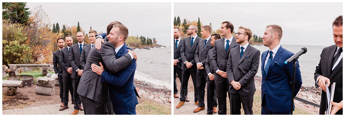 groom in a blue suit at the beach gets a hug from his best man as the ceremony begins and his groomsmen all look on 