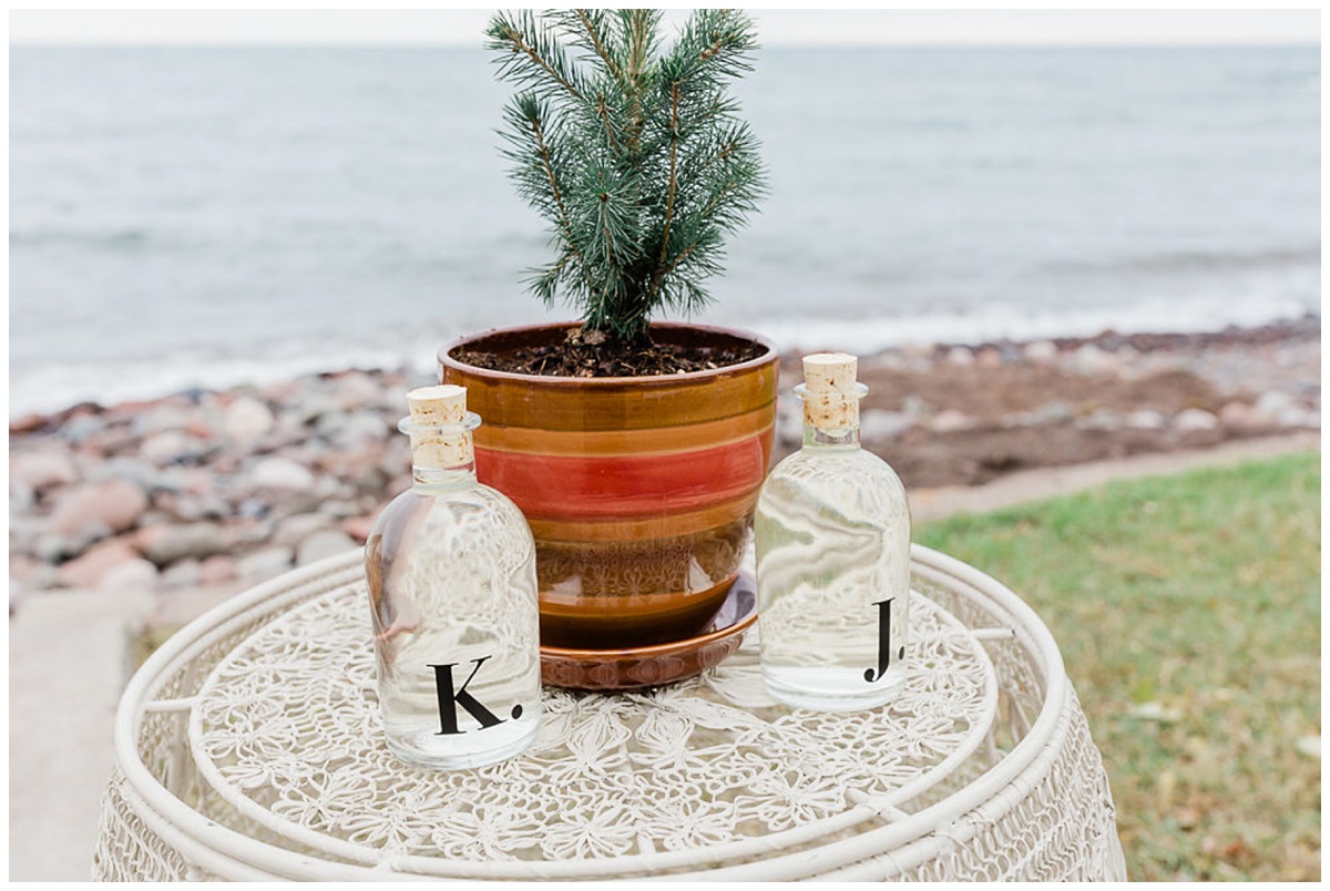 two personalized bottles of water next to a baby pine tree in a planter for a unique wedding ceremony ritual