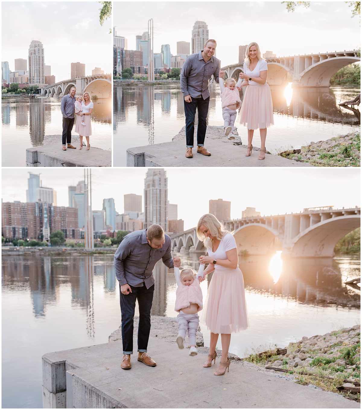 Young husband and wife and their adorable little blonde daughter in pigtails pose in front of the Mississippi River in St. Anthony Main in Minneapolis
