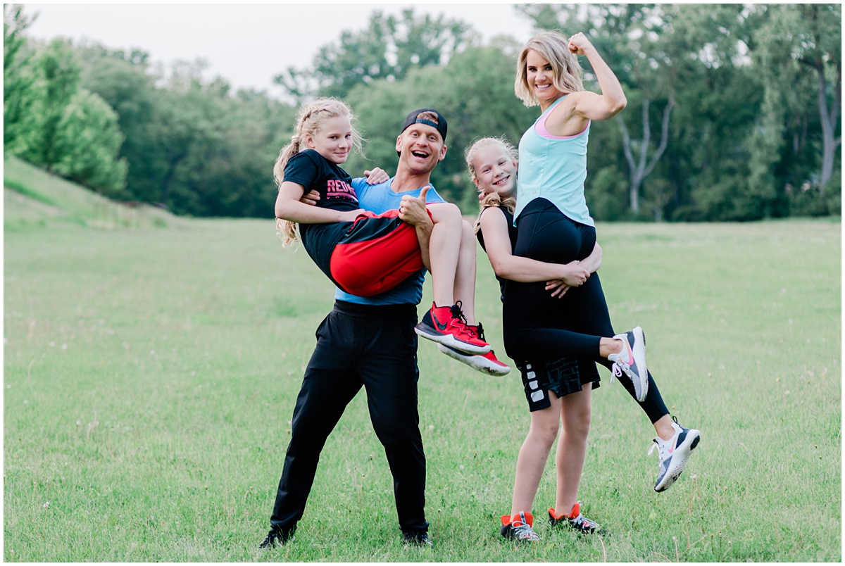 fun family lifestyle photo featuring a family in athletic wear smiling and flexing