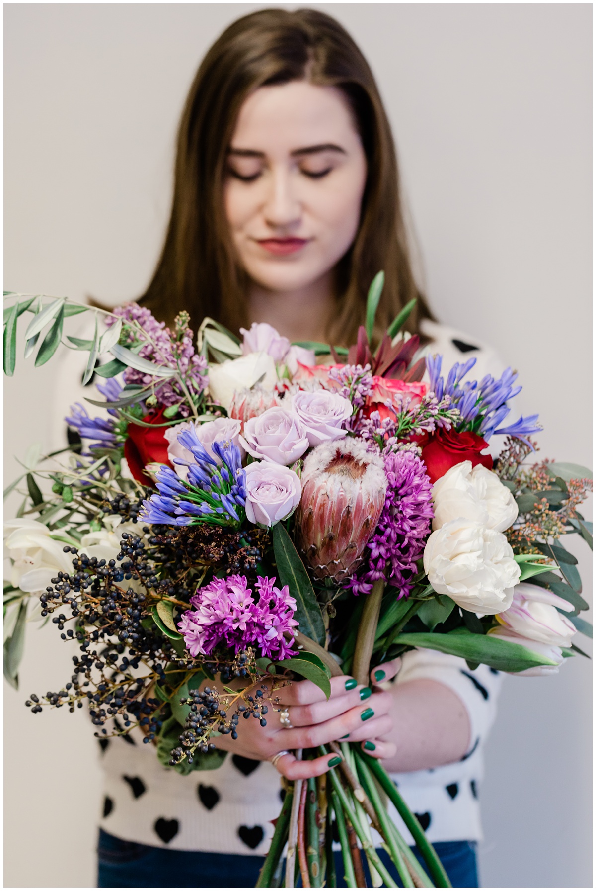 Business branding sessions showing Colorful floral arrangement of deep purples, blues, pinks, creams, and greenery being held by Layla, the owner of Saffron & Grey Floral designs.