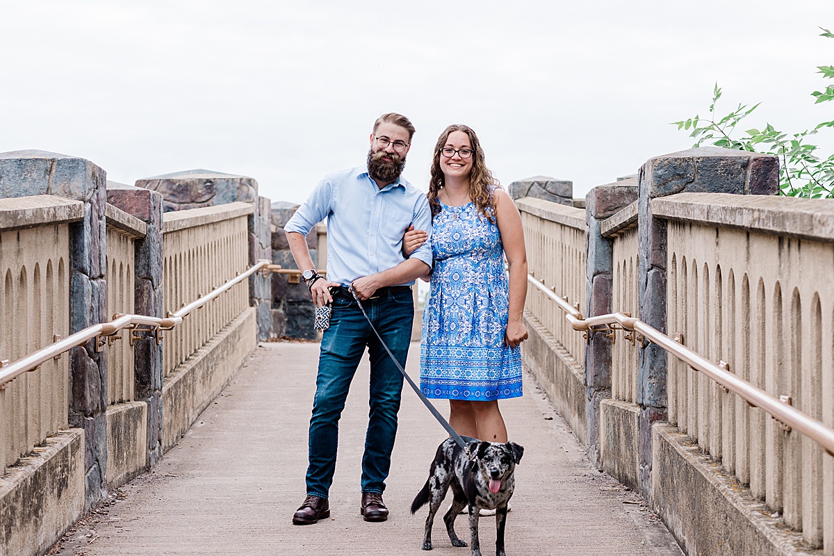 a couple walks their mini aussie dog in Duluth, MN during a morning engagement session