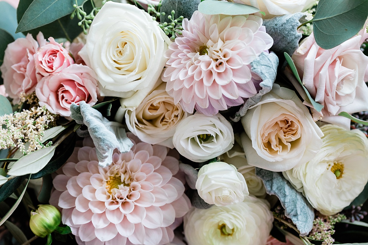 A beautiful bouquet of light pink flowers and sage green leaves capture by wedding photographer Comfort & Cashmere Images.