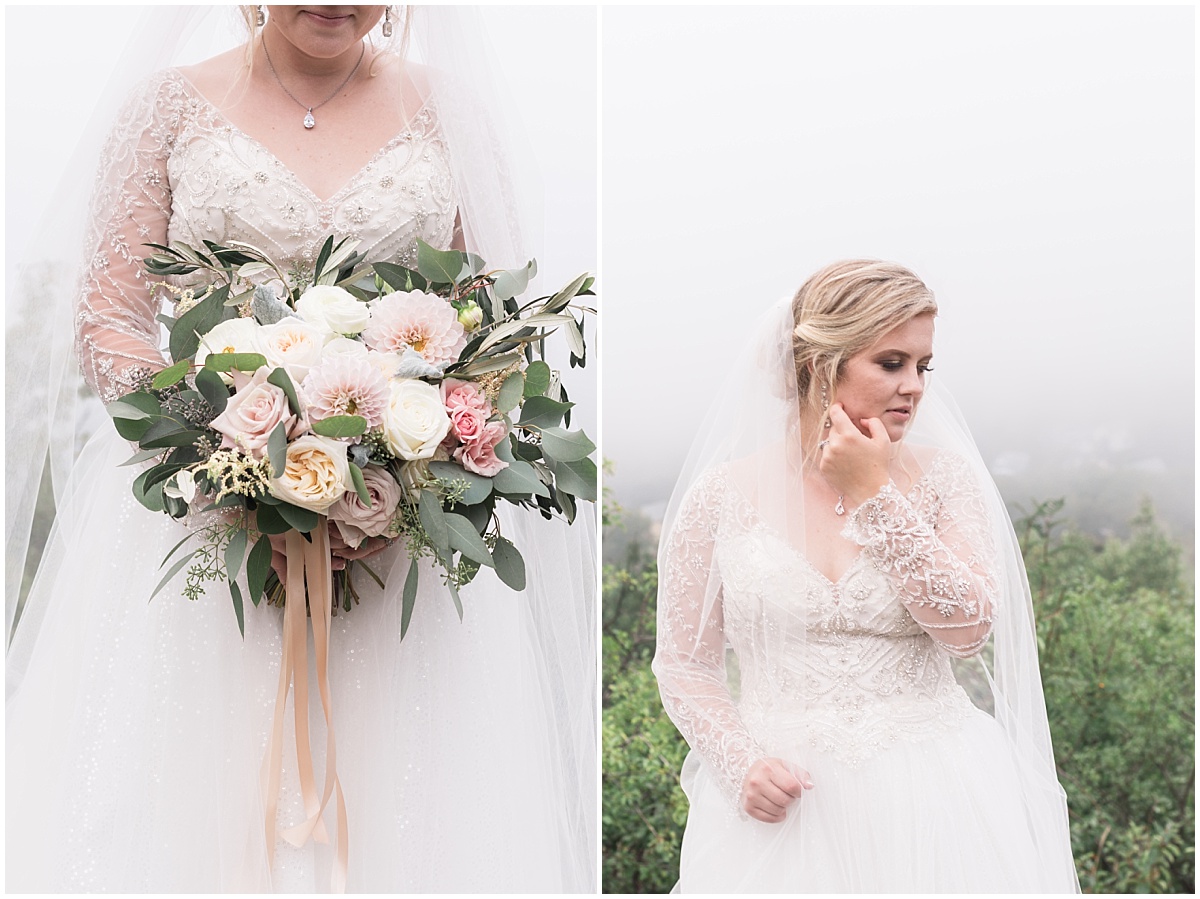 A beautiful bride in a wedding dress and veil holding a bouquet of blush pink flowers and sage greens.