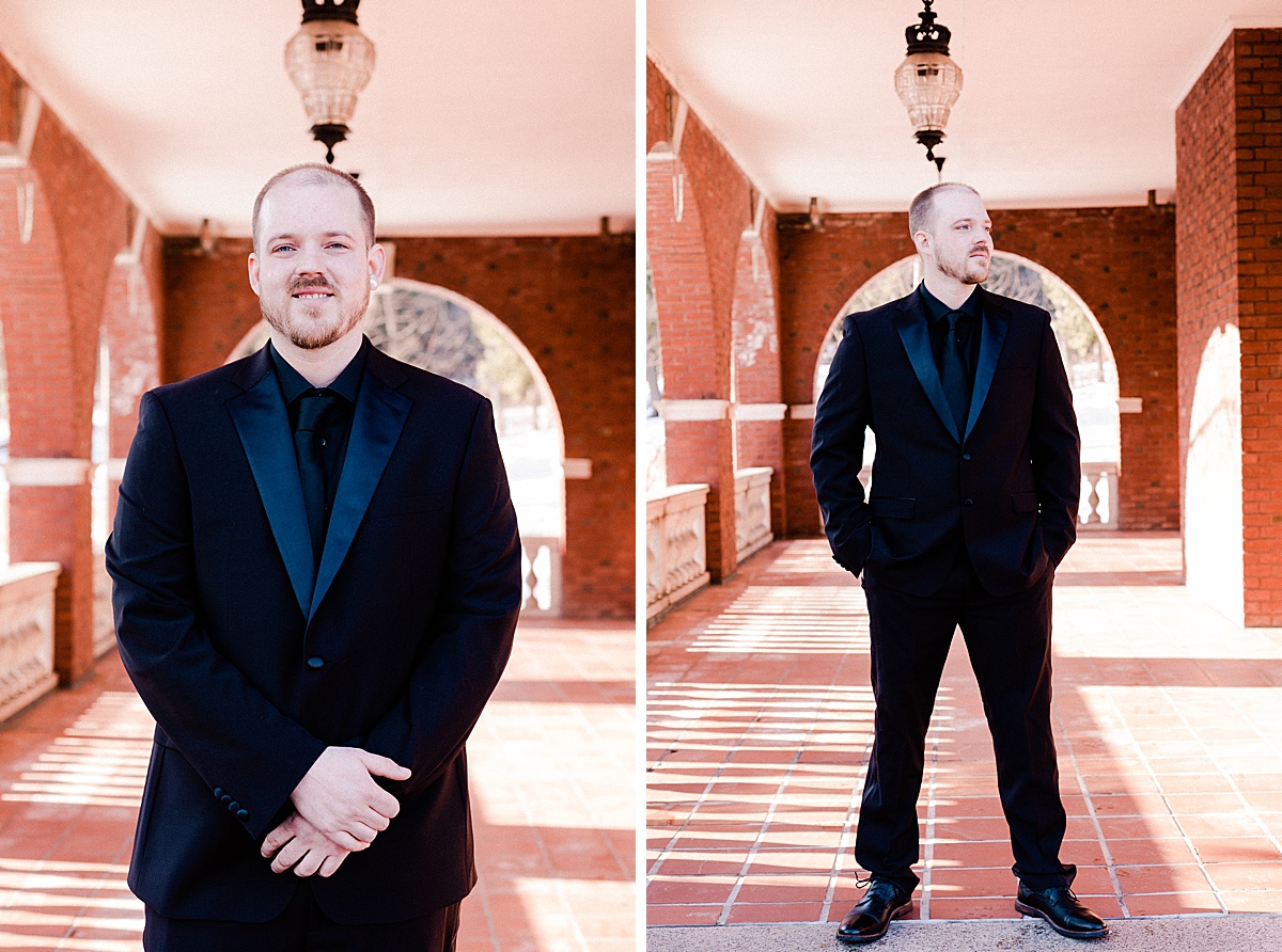 handsome and happy groom wearing a fancy suit with black velvet lapels poses in a brick corridor for comfort and cashmere images at the Glensheen Mansion in duluth