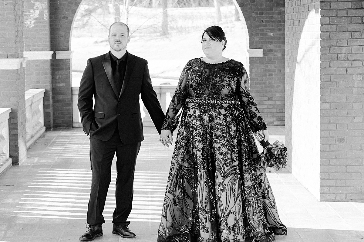 happy married couple stand holding hands on the terrace of Glensheen Mansion looking at photographer comfort and cashmere images