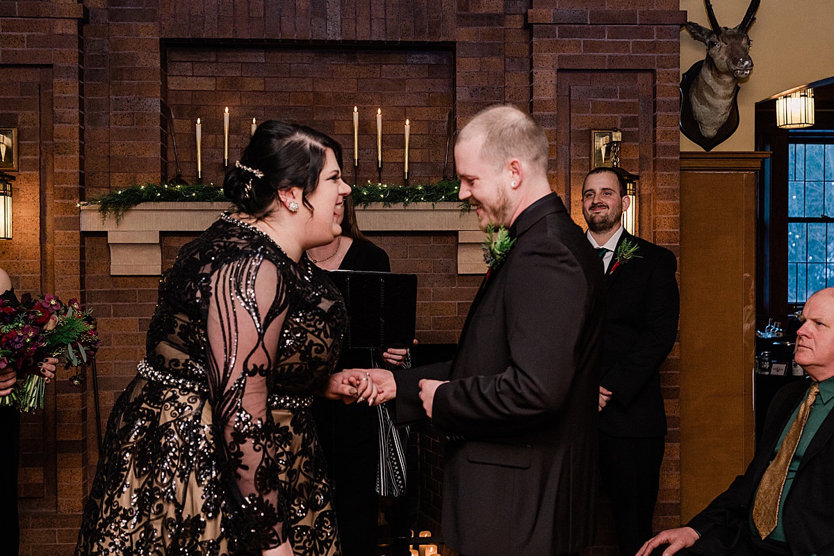 curvy bride wearing black and her groom share a big laugh during their wedding ceremony with comfort and cashmere images at the Glensheen Mansion