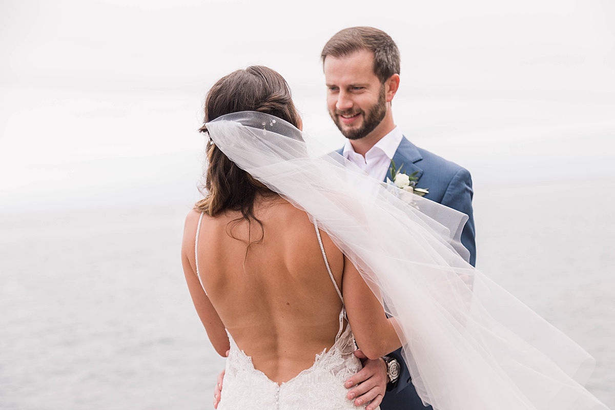 groom looking at bride against lake superior at bluefin bay