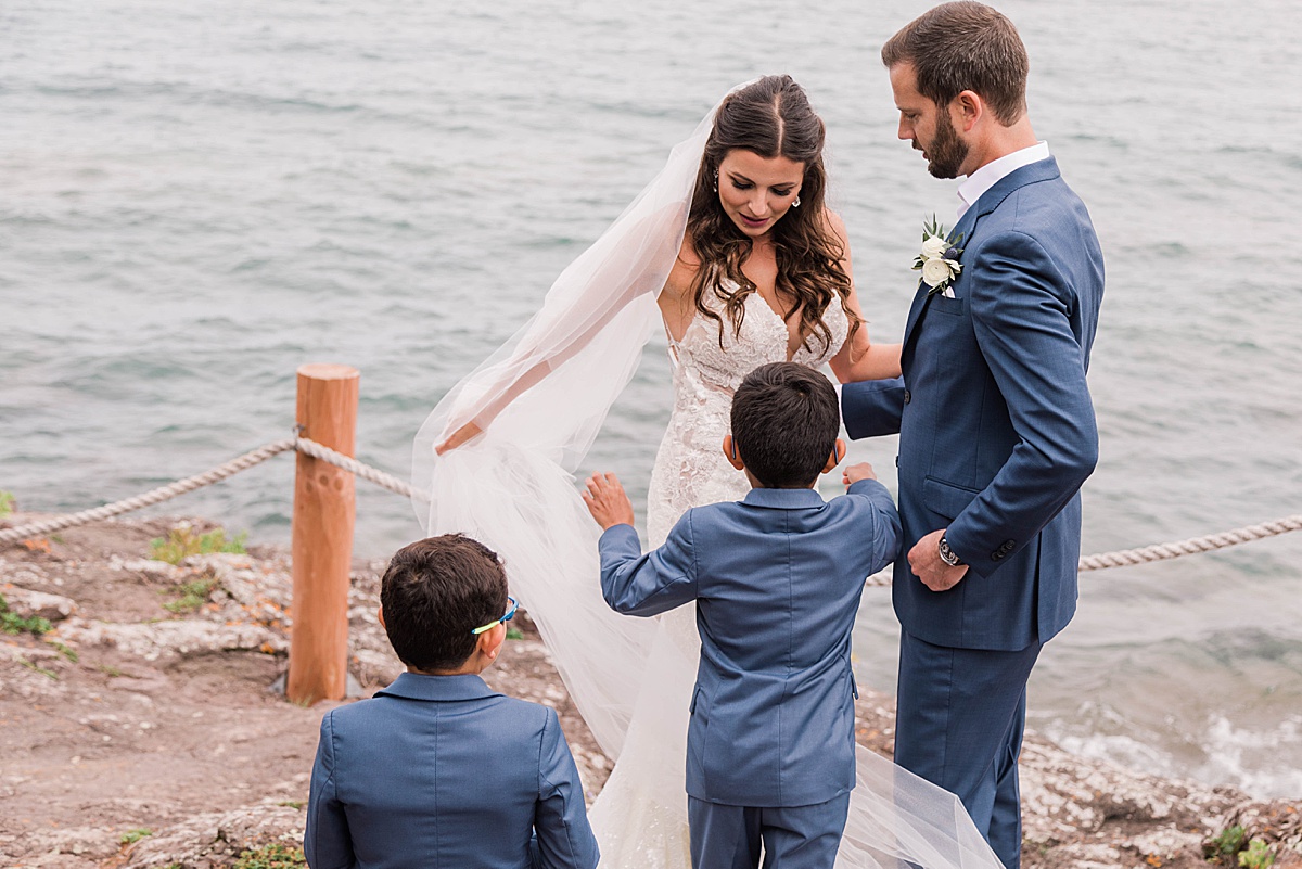 first look at bluefinn bay with bride groom and sons during their intimate elopement with comfort and cashmere images