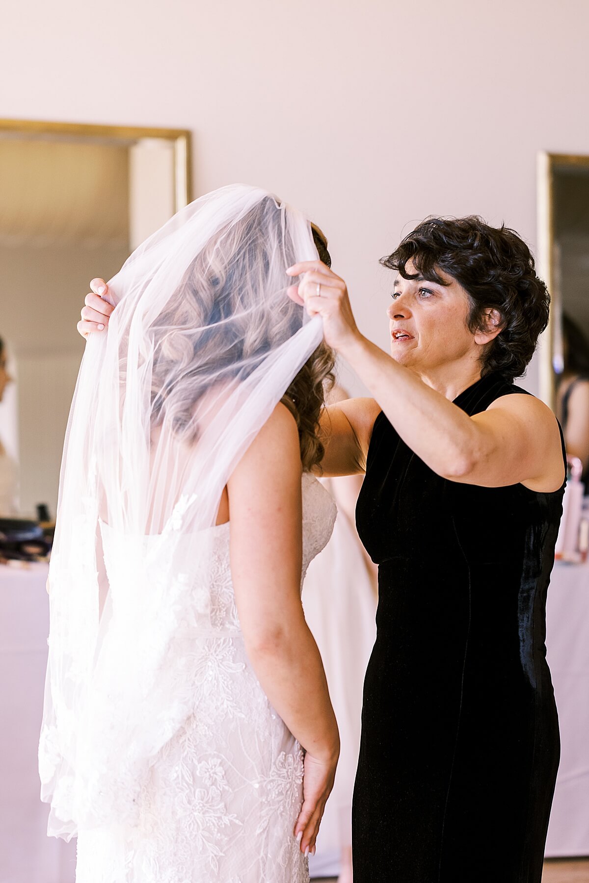 brides mom putting veil on her daughter