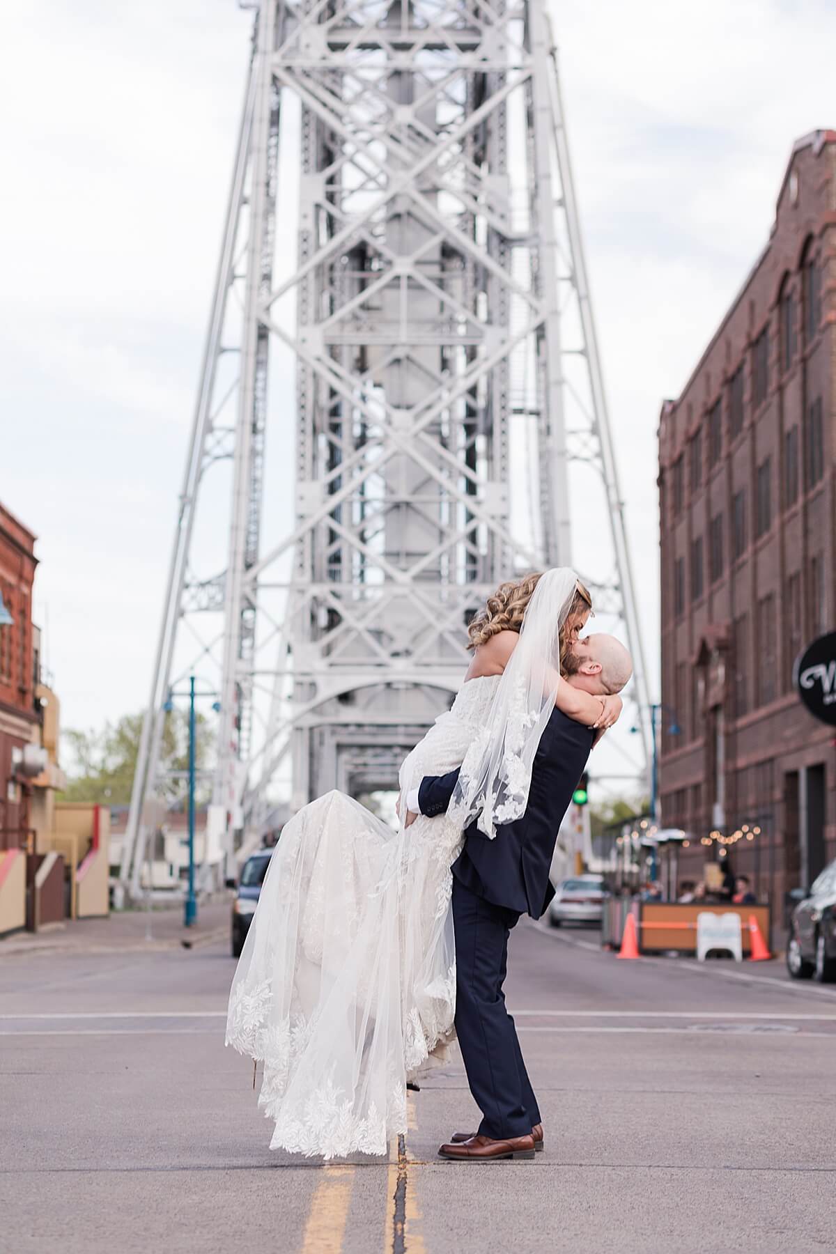bride and groom kissing in front of the lift bridge in canal park