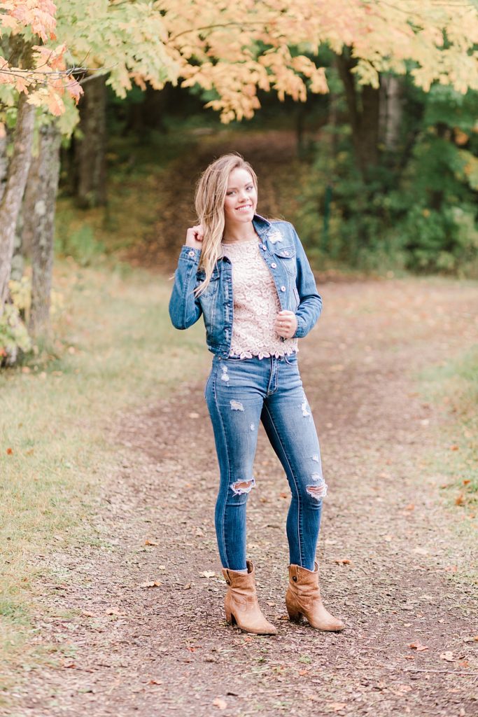Senior Portrait girl wearing jeans pink blouse and jean jacket in bagley nature park