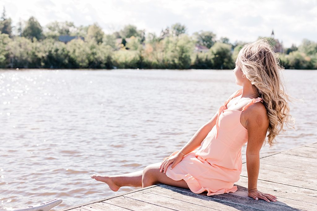 duluth senior session girl sitting on dock facing the water