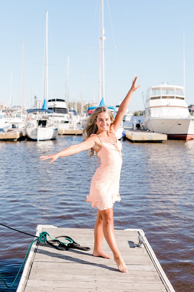 senior girl dancing on docks at barkers island in Wisconsin 