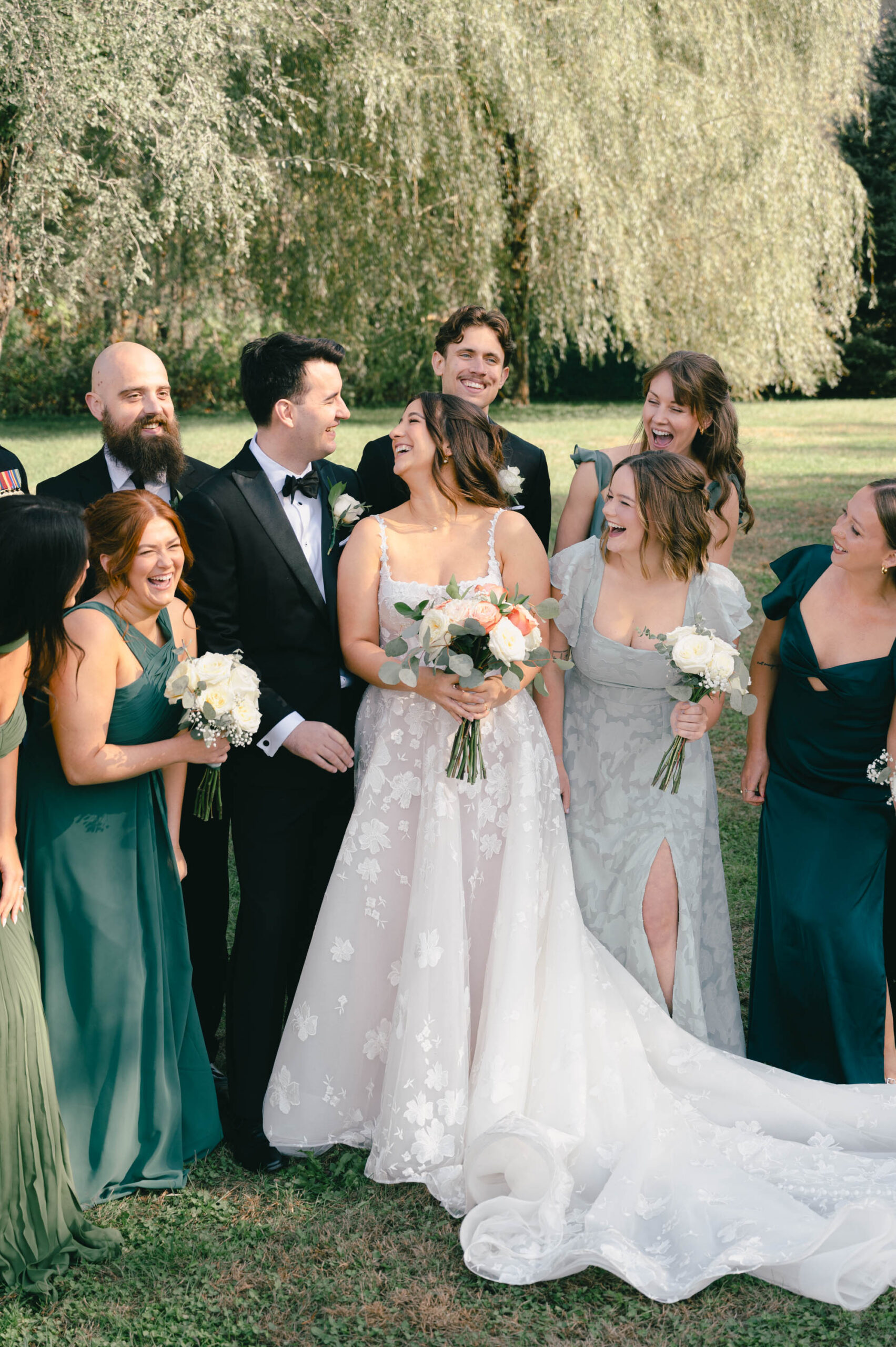 Wedding photograph of bride and groom looking at each other surrounded by their wedding party in Cottage Grove MN